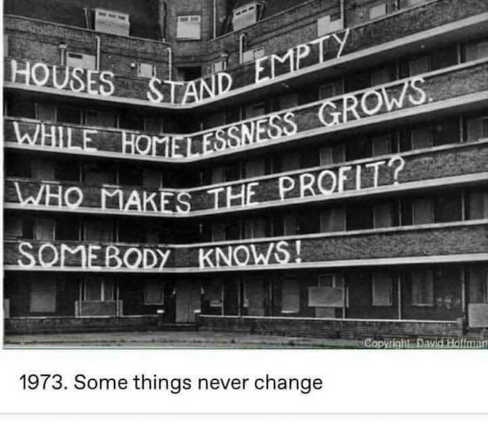 An old building with protest banners about empty houses, illustrating problems with terrible landlords.