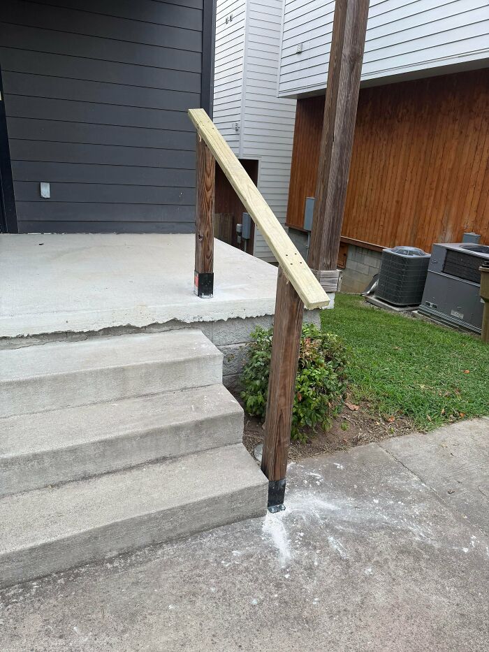 A poorly constructed wooden staircase handrail showing terrible landlord repair work