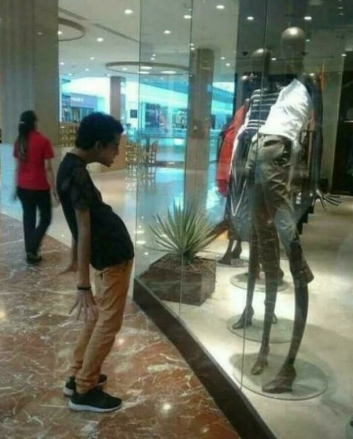 Funny memes showing a man imitating a mannequin with an unusually curved posture inside a shopping mall.