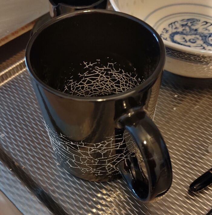 Interesting and cool photos of dried milk forming a spiderweb pattern inside a black mug