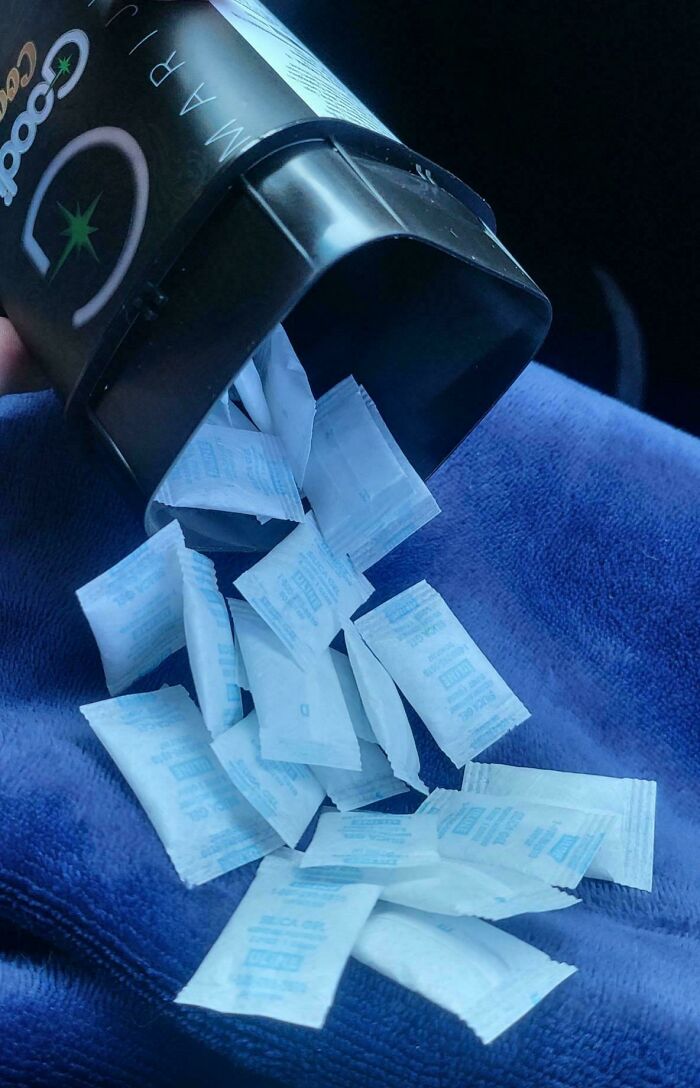 Dozens of silica gel packets poured out of a container, showing one of many funny husband quirks.