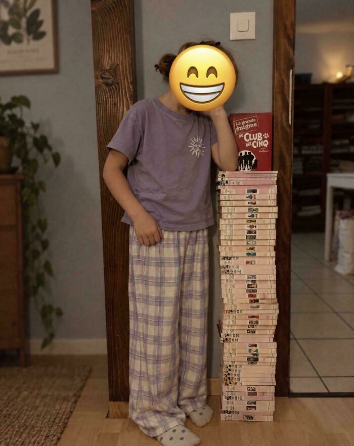 Girl standing next to a stack of books, showing supportive fatherhood