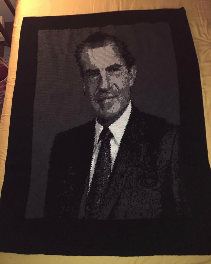 A black and white knitted portrait blanket, representing well-made creations that are awful to look at.