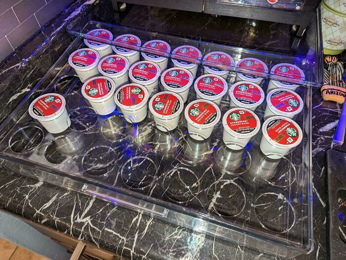 A coffee pod storage drawer with pods organized in a chaotic, non-sequential order