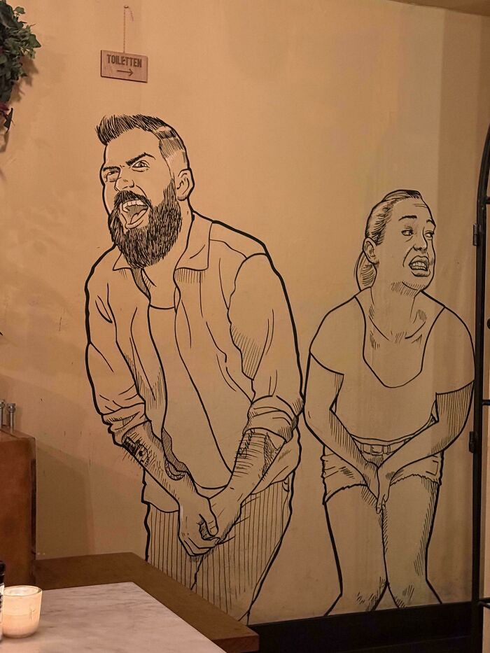 A wall drawing of a man and woman crossing their legs in discomfort, showcasing awful creations that are well made.