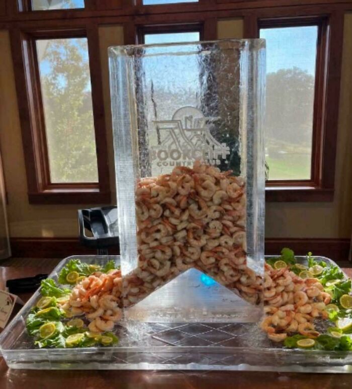 Large ice sculpture filled with fresh shrimp displayed at an event, part of creations awful to look at.