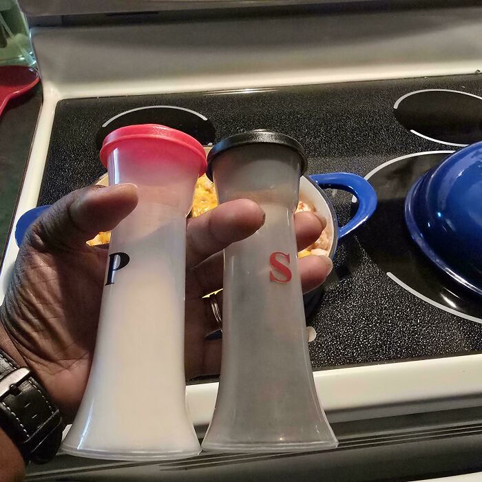 Hand holding salt and pepper shakers with letters swapped, showcasing husbands' funniest quirks.