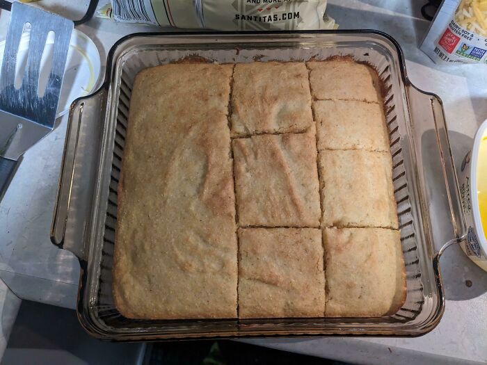 Freshly baked cornbread unevenly sliced in a glass dish, illustrating husbands' funniest quirks.