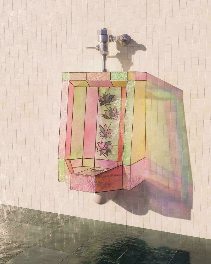 A decorative stained glass urinal on a tiled wall, representing awful creations.
