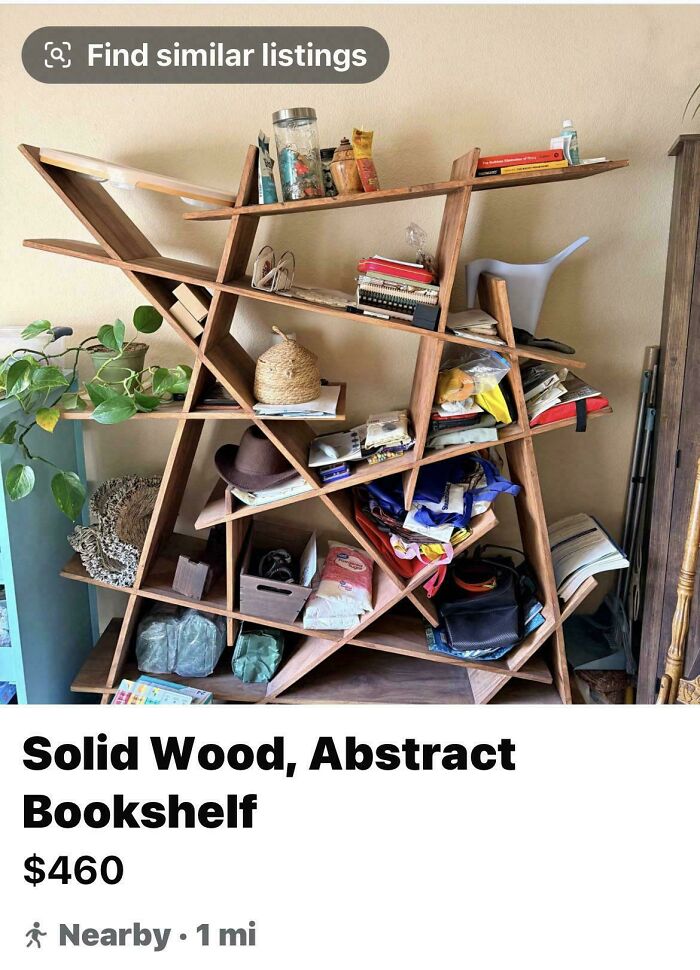 An oddly angled wooden bookshelf filled with items, showing awful creations that are well made.