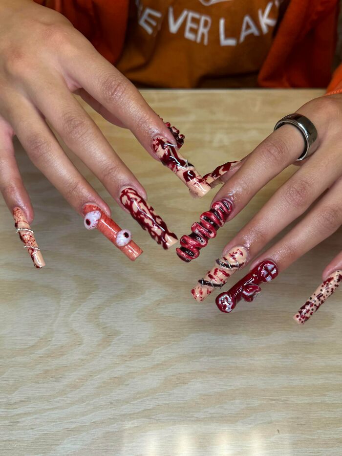 Gory red nail art design with eyeballs and stitches, among creations awful to look at but well-made.