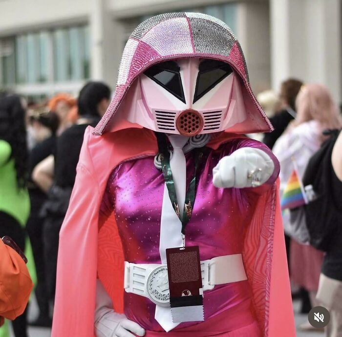 Awful creations showing a cosplayer in a sparkly pink Darth Vader costume pointing forward