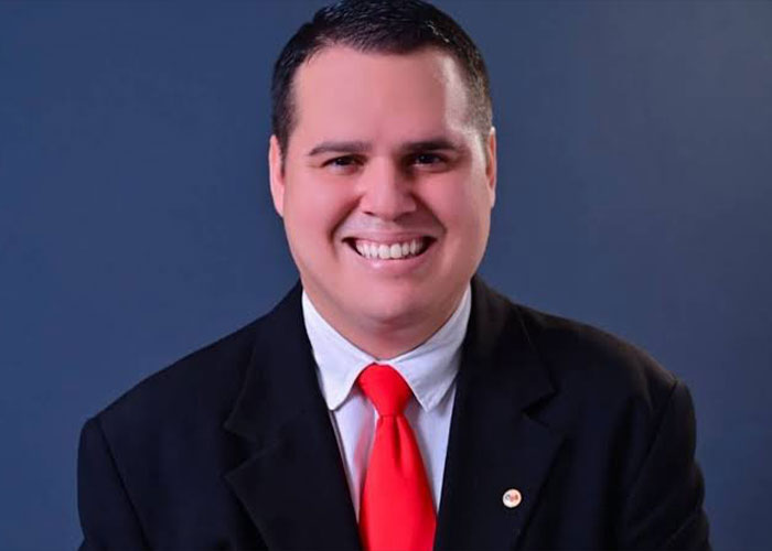 A smiling boss in a black suit with a red tie, looking directly at the camera A smiling boss in a black suit with a red tie, looking directly at the camera