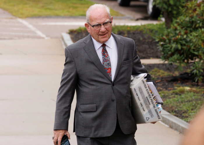 Lawyer with glasses and a gray suit holding a USPS box during the Lindsay Clancy trial, which ended in a mistrial. Lawyer with glasses and a gray suit holding a USPS box during the Lindsay Clancy trial, which ended in a mistrial.