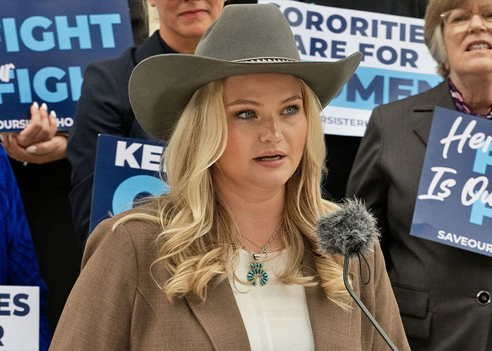 A woman in a cowboy hat speaking at a press conference regarding the sorority sisters legal case.