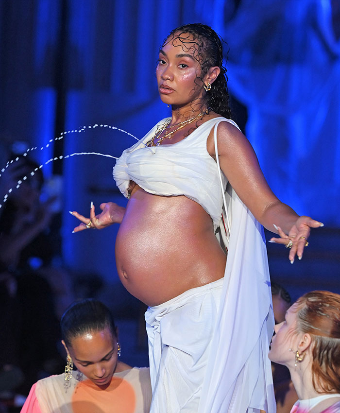 A pregnant star during a runway appearance featuring gushing liquid streams