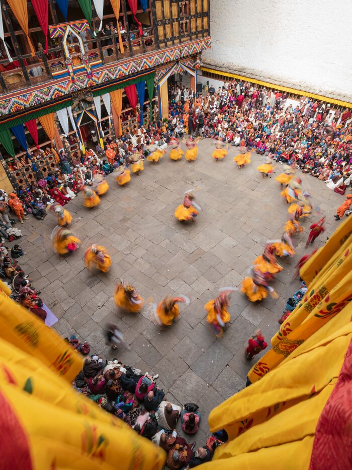 Remarkable travel photos capturing a traditional dance performance in a vibrant courtyard with an audience.