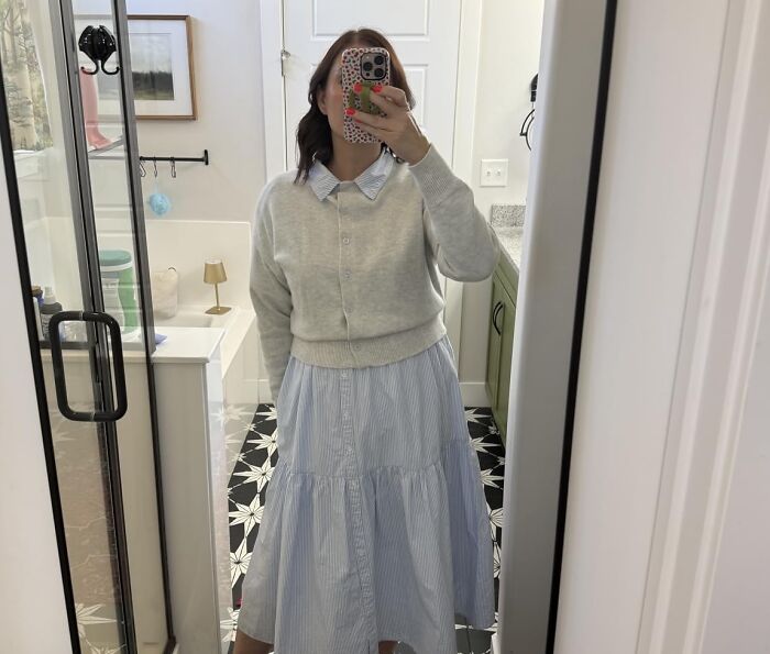 A woman wearing a cropped grey cardigan over a striped dress, a Prime Big Deal Days pick