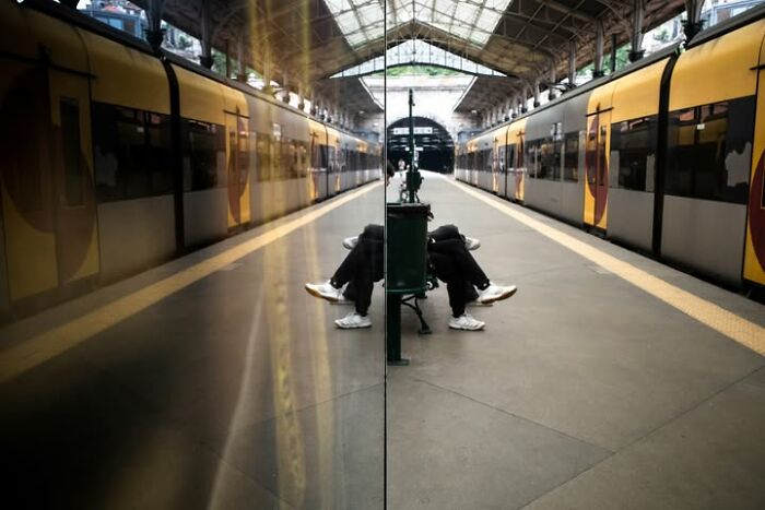 A street photographer captures a reflection of a train station, creating a symmetrical, coincidental scene.