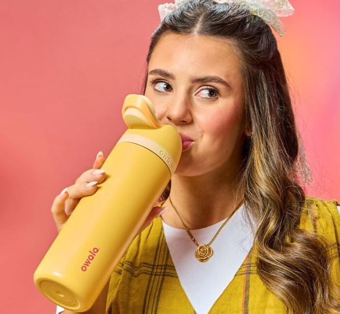 A woman drinks from a yellow Owala water bottle, highlighted in Prime Big Deal Days.