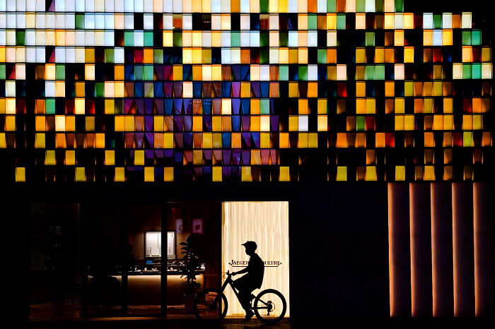 Minimalist architecture photography showcases a vibrant, colorful building facade and a cyclist.