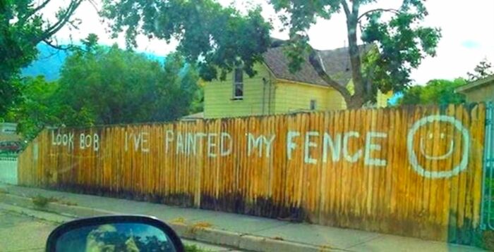 A funny fence with Look Bob I've Painted My Fence and a smiley face, one of many silly signs.