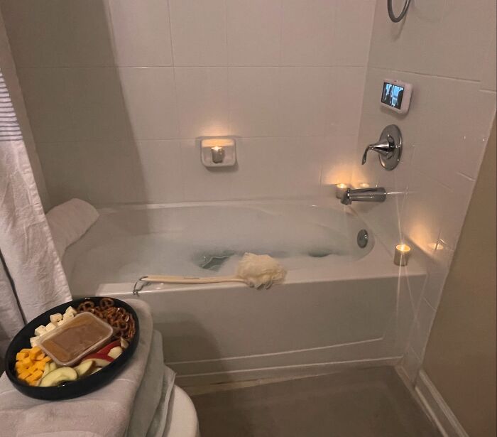 A relaxing bath with candles and a snack tray, proof of finding the right man for self-care.
