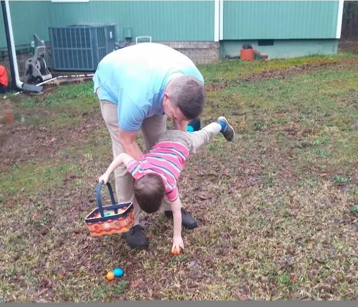 A man helping a child collect Easter eggs, showing proof they found the right man.