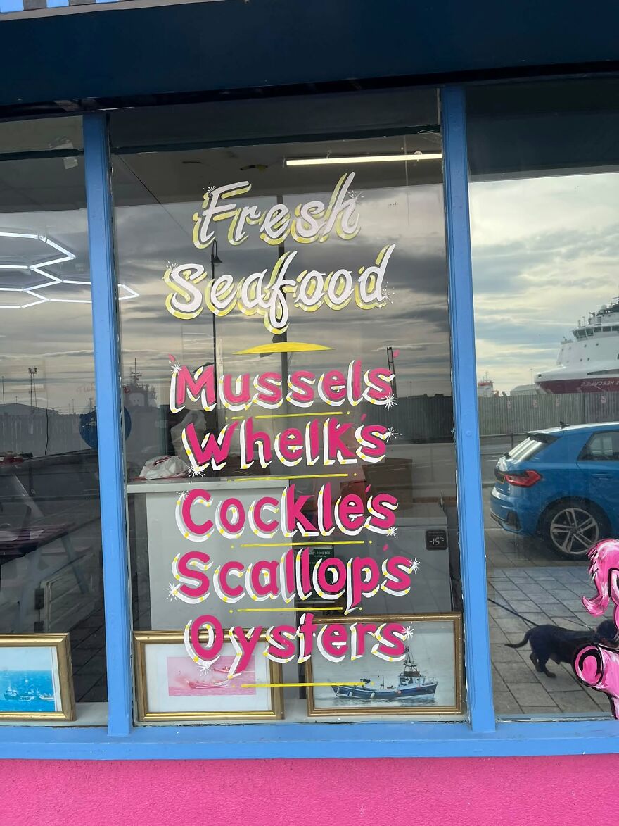 A restaurant window listing fresh seafood with grammar fails spelling whelks as whells.