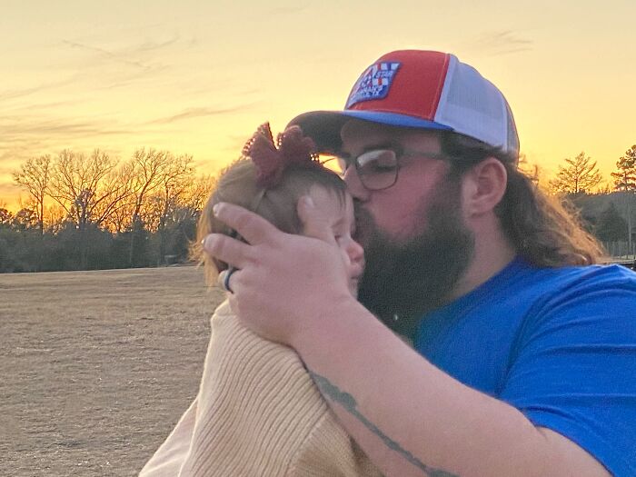 A man kissing a baby on the forehead at sunset, showing proof they found the right man.