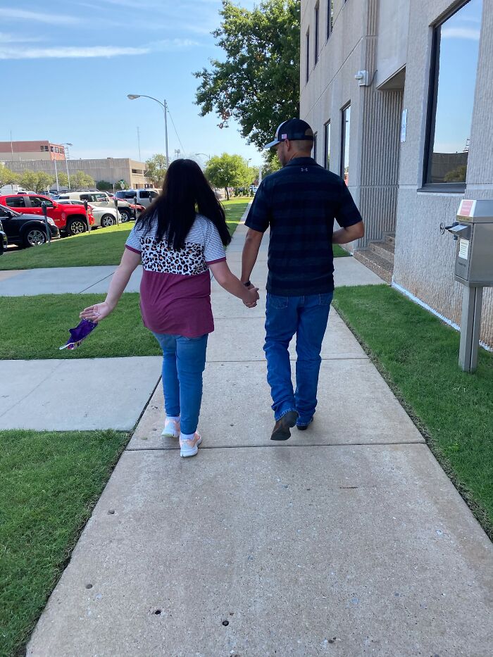 A couple holds hands walking down a sidewalk, symbolizing finding the right man and love together.