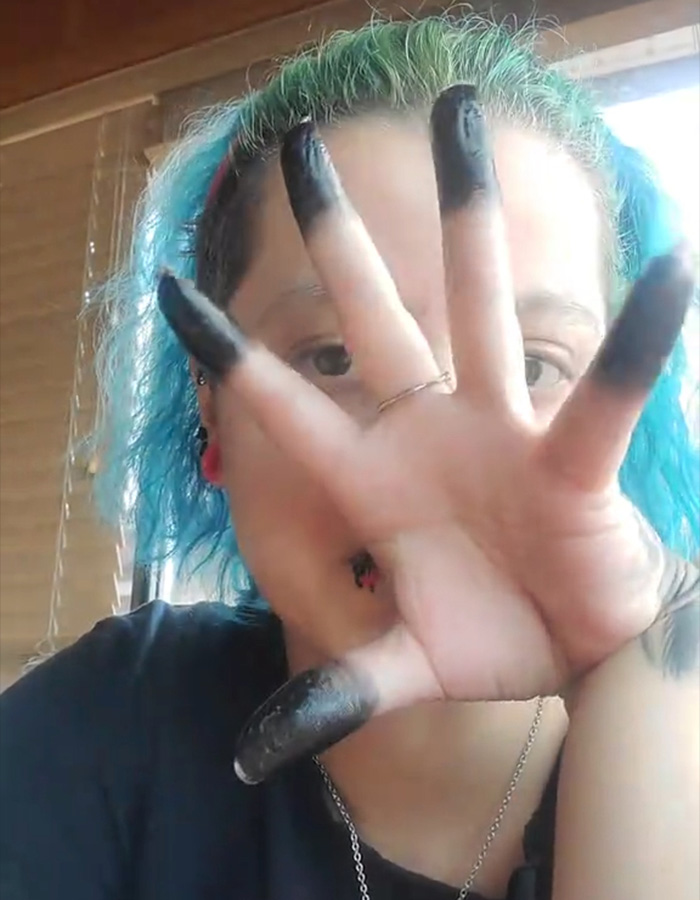 Woman showing her hand with the controversial fingertip tattoo trend in solid black ink Woman showing her hand with the controversial fingertip tattoo trend in solid black ink