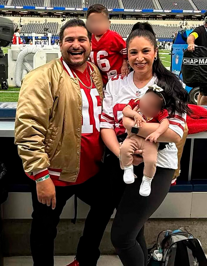 Family of four at football stadium wearing team jerseys