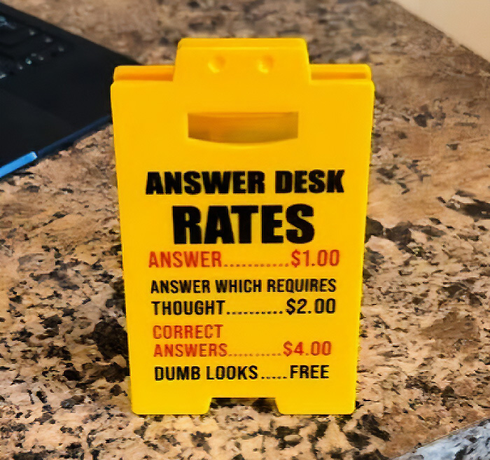 A silly-funny sign that lists answer desk rates, with dumb looks being free.