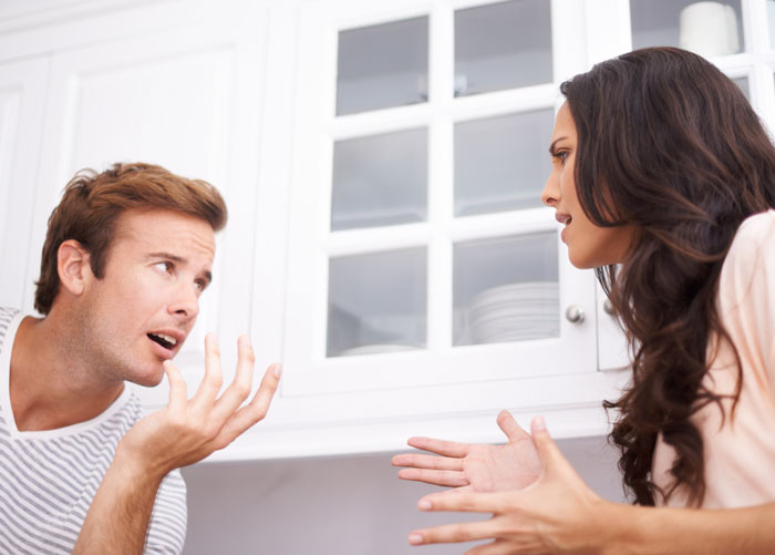 Couple arguing in a kitchen, depicting a common scenario where relationships lead to full-time headaches.