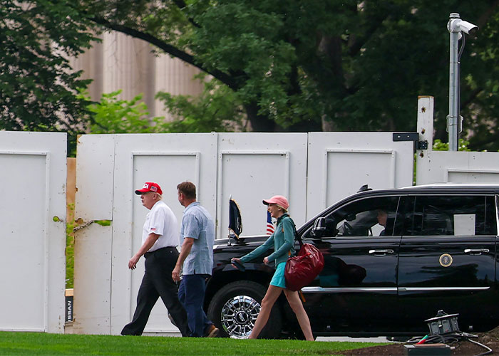 Trump and Natalie Harp walking toward a black SUV, drawing attention to viral image.