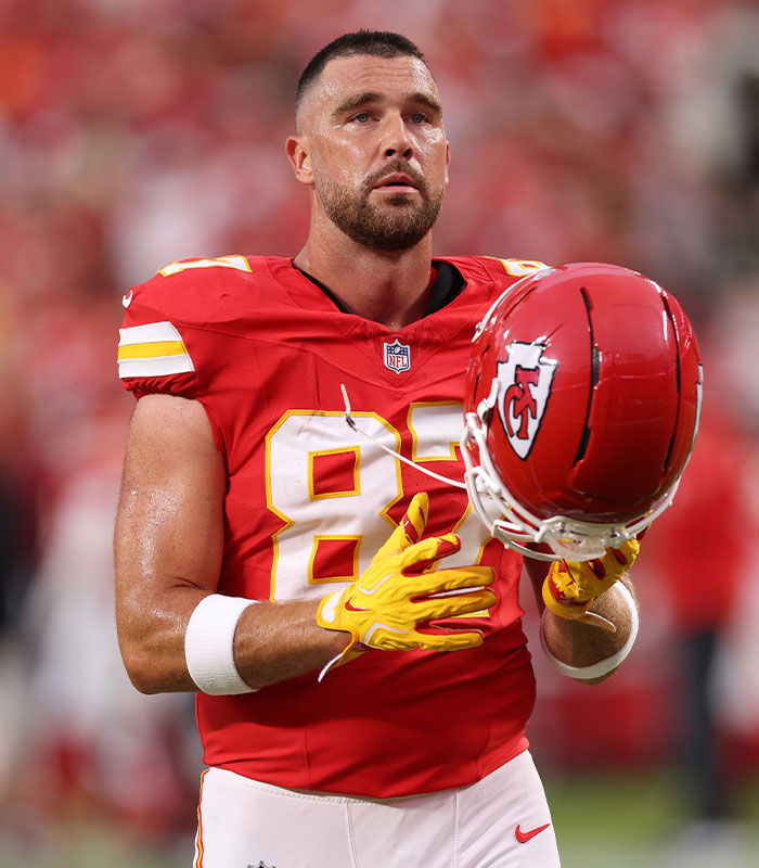 Travis Kelce wearing a Chiefs jersey looking determined on the football field Travis Kelce wearing a Chiefs jersey looking determined on the football field
