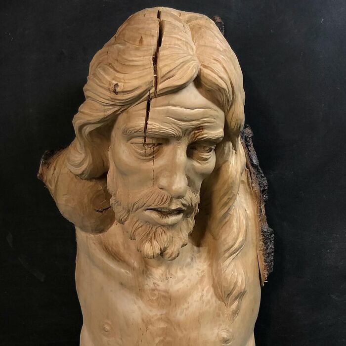 Wood sculpture of a bearded man with a split down his head by a Polish artist