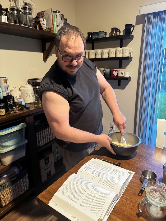 A man with glasses whisking ingredients in a bowl in a kitchen, showing sweet proof of finding the right man.