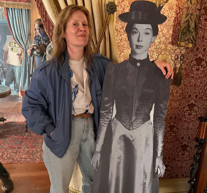 A behind the scenes photo of a woman standing next to a cardboard cutout from the Lizzie Borden Series A behind the scenes photo of a woman standing next to a cardboard cutout from the Lizzie Borden Series
