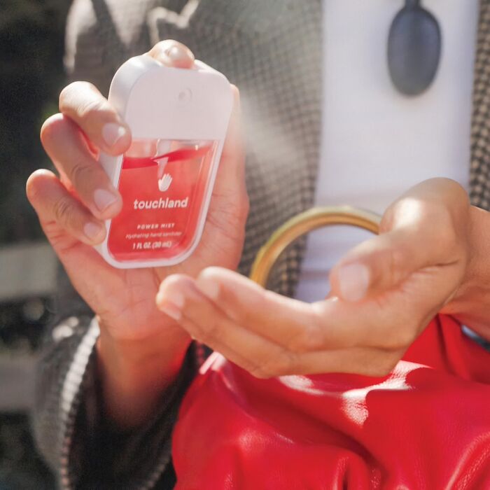 Hands spraying Touchland hand sanitizer, featured in Prime Big Deal Days selection.