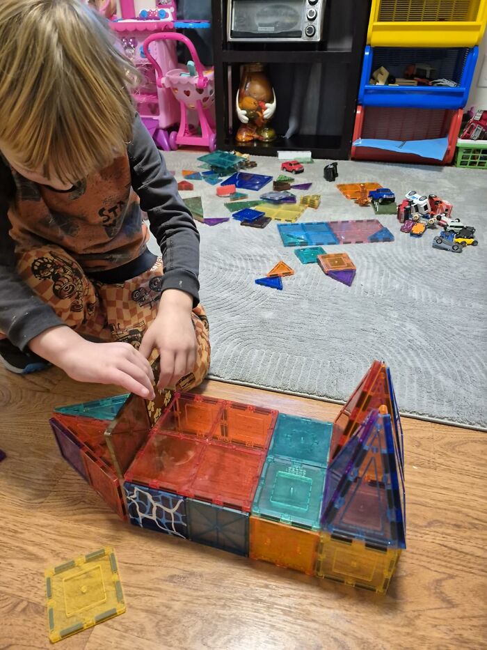 A young boy building a toy structure with magnetic tiles, perfect for Prime Big Deal Days.