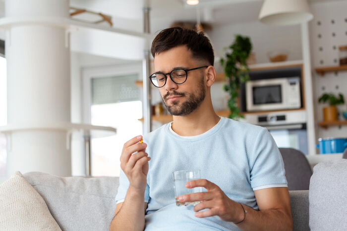 A man about to take a pill with water, illustrating strange patients and their self-medication habits