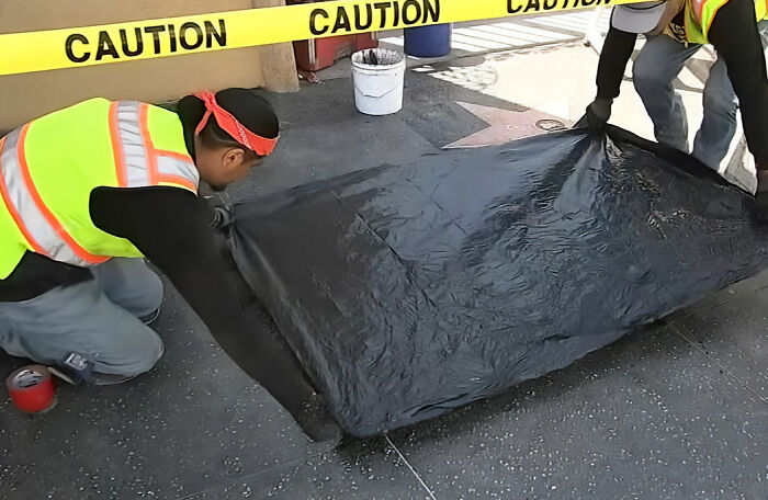 Workers covering a star on the Hollywood Walk of Fame with a black tarp, disrespecting Dolly Parton after her passing. Workers covering a star on the Hollywood Walk of Fame with a black tarp, disrespecting Dolly Parton after her passing.