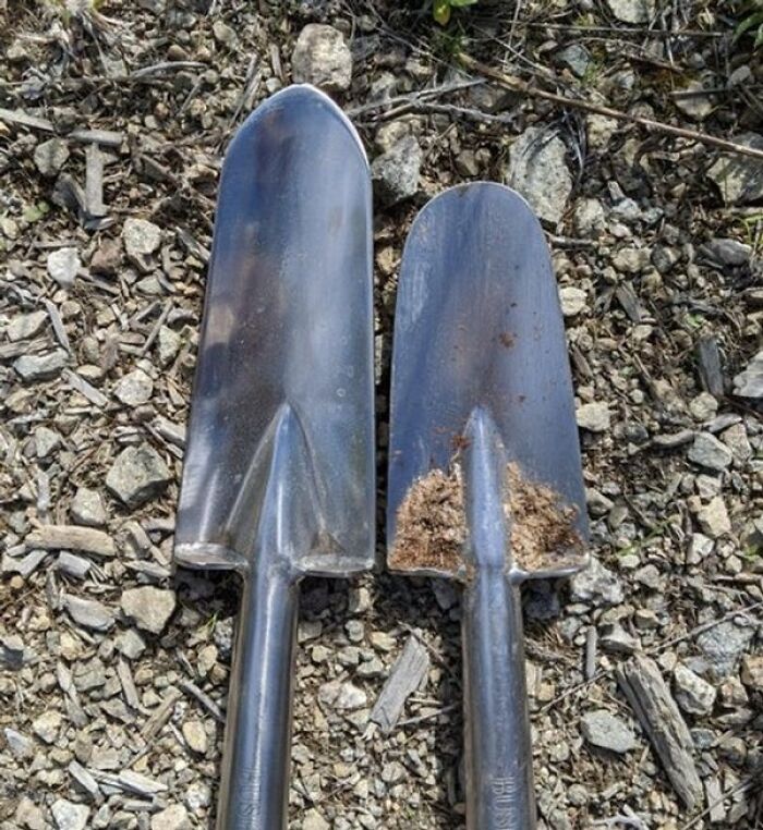 Two metal garden trowels showing the wear on the left trowel after digging in rocky soil.