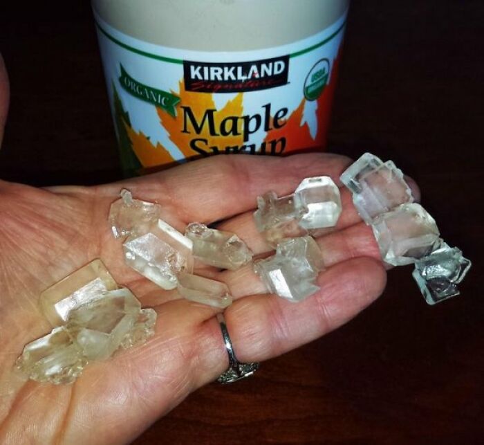 Large clear sugar crystals formed inside a maple syrup container, showcasing interesting photos of natural science
