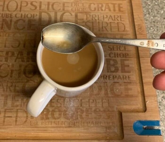 A spoon hovering over a coffee cup, revealing a perfect circular shadow in interesting photos of light physics