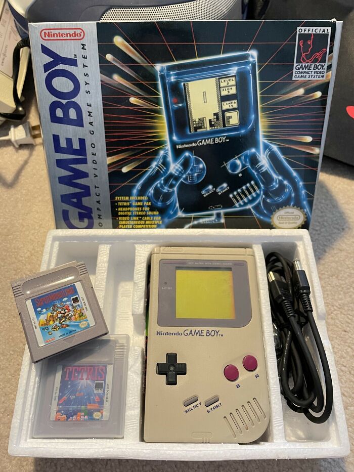 A boxed Nintendo Game Boy with cartridges, capturing the essence of '80s retro tech and handheld gaming.