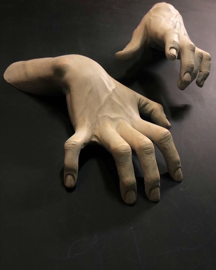 Lifelike wood sculptures of human hands with visible veins carved by a Polish artist