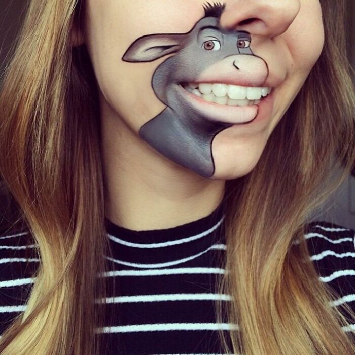 Weird face paint illusion of cartoon donkey on woman's cheek